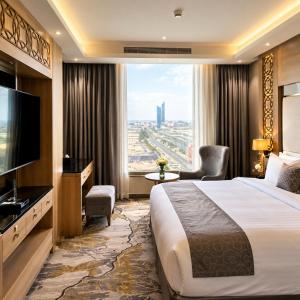 a hotel room with a large bed and a large window at Medhal Hotel in Jeddah