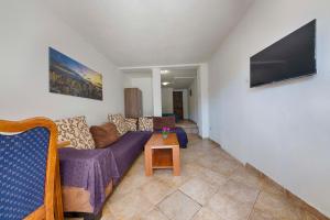 a living room with a couch and a flat screen tv at FIRST ROW Sea View in Šušanj