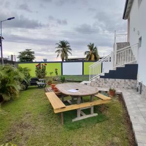 a picnic table in the backyard of a house at Hébergement Studio Cosy AFWA in Les Abymes