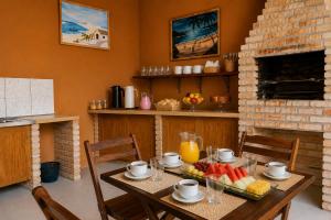 a table with fruit and juice on it in a kitchen at Maruá Pousada da Lagoa in Jijoca de Jericoacoara