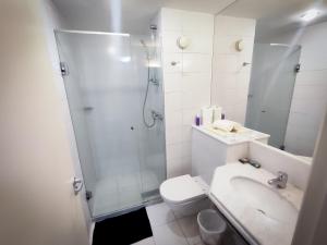 a bathroom with a shower and a toilet and a sink at VM Flats Guarulhos Aeroporto in Guarulhos