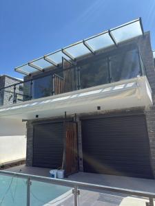 a house with two garage doors and a balcony at Grey Pearl Apartments in Nea Kallikrateia
