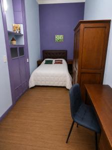 a small bedroom with a bed and a chair at Hotel Histórico San Telmo in Buenos Aires