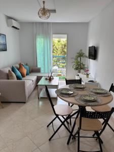 a living room with a table and chairs and a couch at Cabo Alegre in Martil
