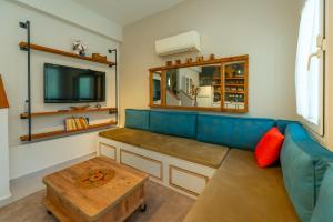 a living room with a blue couch and a tv at HENNA VILLA in Fethiye