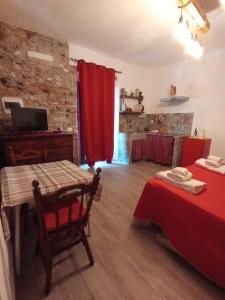 a room with two beds and a table and red curtains at Podere il Gallo Agriturismo in Campiglia Marittima