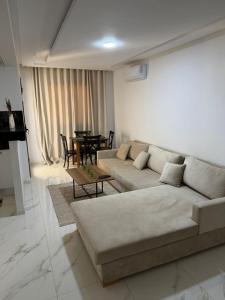 a living room with a couch and a table at Lux appartement S plus deux a hay el wahat in El Aouina Station