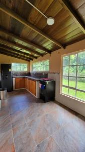 an empty room with a large kitchen with windows at Cocoloco's Lodge in El Valle