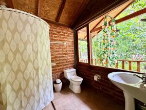 ein Badezimmer mit Toilette, Waschbecken und Fenster in der Unterkunft Munay Wasi by Hospedaje Puntzán in Baños