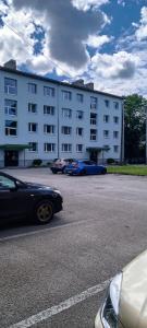a large white building with cars parked in front of it at Uueka Külaliskorter in Kuressaare +9 photos