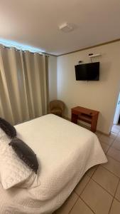 a bedroom with a bed and a tv on the wall at Hosteria Puerta del Sol in Caldera