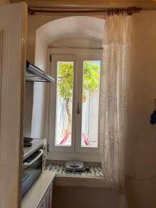 a kitchen with a window and a door with a view at Marthas Traditional House in Symi +37 photos