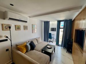 a living room with a couch and a tv at Magnifique appartement Bahia Smir Fnideq Mdiq nord in Fnidek