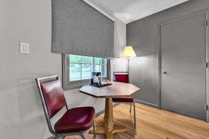 a room with a table and a chair and a window at Harvest Drive Family Inn - Renovated Rooms in Gordonville +38 photos