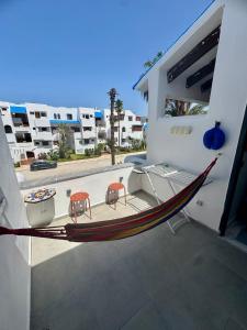 a hammock on the side of a building with two chairs at Magnifique appartement Bahia Smir Fnideq Mdiq nord in Fnidek