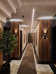 a hallway in a building with wooden walls and a plant at Hotel Shopi Residence in Elbasan +42 photos