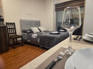 a table with a wine glass on a table with a bed at Premium 21 Suites in La Paz