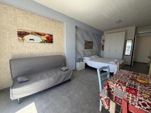 a room with two beds and a couch and a table at Al Baglio di Sant'Elia in Santa Flavia