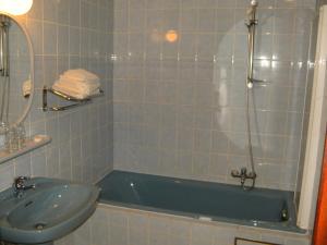 ein Badezimmer mit einer Badewanne und einem Waschbecken in der Unterkunft B&B Le Petit Normand in Jalhay