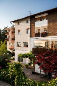 an apartment building with a balcony and plants at Hotel Scoiattolo in Baselga di Pinè