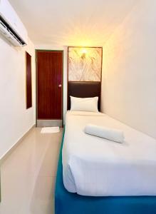 a bedroom with a large white bed and a door at Hotel EcoStay at Chow kit in Kuala Lumpur