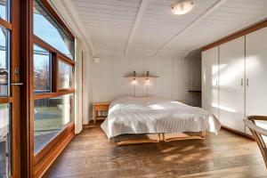 a bedroom with a bed and a large window at C11761-Hemmet-Sydmarken-27 in Falen