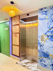 an elevator in a building with a painting on the wall at Hotel EcoStay at Chow kit in Kuala Lumpur