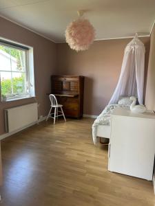 a bedroom with a bed and a dresser and a window at House close to the forest and the lake in Huskvarna