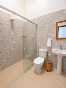 a bathroom with a shower and a toilet and a sink at Maruá Pousada da Lagoa in Jijoca de Jericoacoara