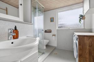 a white bathroom with a sink and a toilet at 40583-Juelsminde-Pot-Strandby-119 in Sønderby