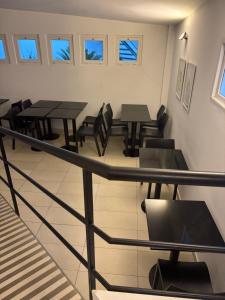 a dining room with tables and chairs and windows at Patios de City Bell Hotel and Apartments in City Bell