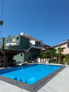 a swimming pool in front of a building at Rajan Rooms in Vlorë
