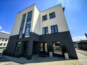 a large white building with black windows at POPIELATE Apartamenty in Żywiec