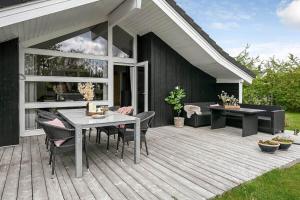 a wooden deck with a table and chairs on it at C11266-Hemmet-Egernvej-10 in Hemmet