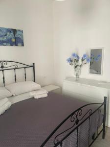 a bedroom with a bed and a vase of flowers at Case vacanza Controvento in Palermo