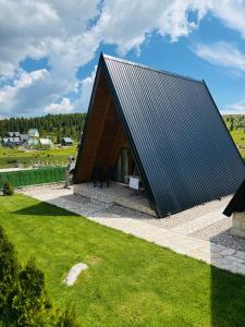 a large wooden house with a black roof at A Frame Houses ANS Zabljak in Žabljak