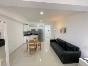 a living room with a black couch and a table at AVENTURA SUITES playa LOS CORALES - great location! in Punta Cana