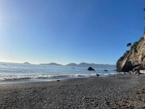 a beach with a rocky shore and the ocean at Villa Vecchia Fontana al mare - Tra Liguria e Toscana tra Viaregggio, Forte dei Marmi e Cinque Terre- Haus am Meer bei la Spezia in Bocca di Magra