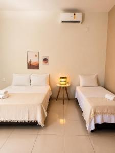 two beds sitting next to each other in a room at Maruá Pousada da Lagoa in Jijoca de Jericoacoara