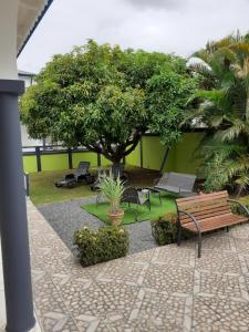 a park with benches and a tree in a courtyard at Hébergement Studio Cosy AKOSSOUA in Les Abymes