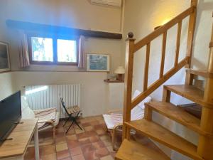 a living room with a staircase and a television at Gîte de la Garriguette in Rasteau
