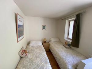a bedroom with two beds and a window at Gîte de la Garriguette in Rasteau