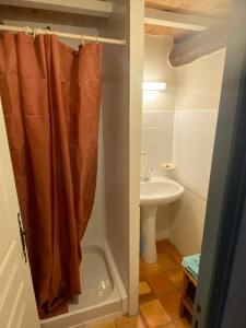 a bathroom with a shower curtain and a sink at Gîte de la Garriguette in Rasteau +8 photos