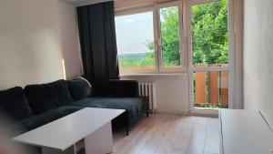 a living room with a couch and a large window at Jura Horizon in Myszków