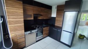 a kitchen with wooden cabinets and a stove top oven at Jura Horizon in Myszków +5 photos