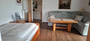 a living room with a couch and a table at Uschi's guest apartment in Ruderting