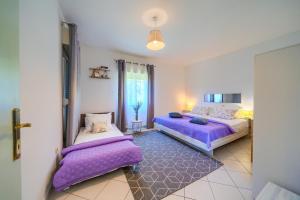 two beds in a room with purple pillows at Villa with pool near Split in Krušvar +49 photos