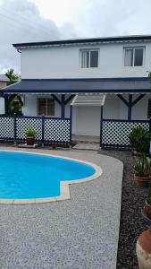 a house with a swimming pool in front of a house at Hébergement Studio Cosy AKOSSOUA in Les Abymes
