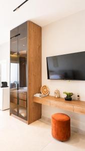 an orange stool in a room with a tv at O'Det Luxury Rooms & Apartments in Sarandë