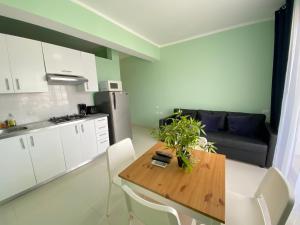 a kitchen with a wooden table with chairs and a couch at AVENTURA SUITES playa LOS CORALES - great location! in Punta Cana